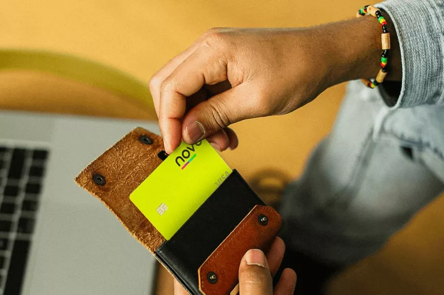 Homem guardando cartão de crédito novücard na carteira