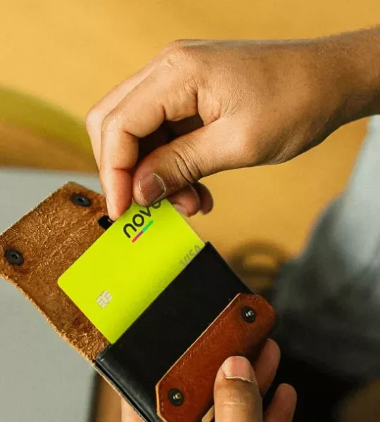 Homem guardando cartão de crédito novücard na carteira