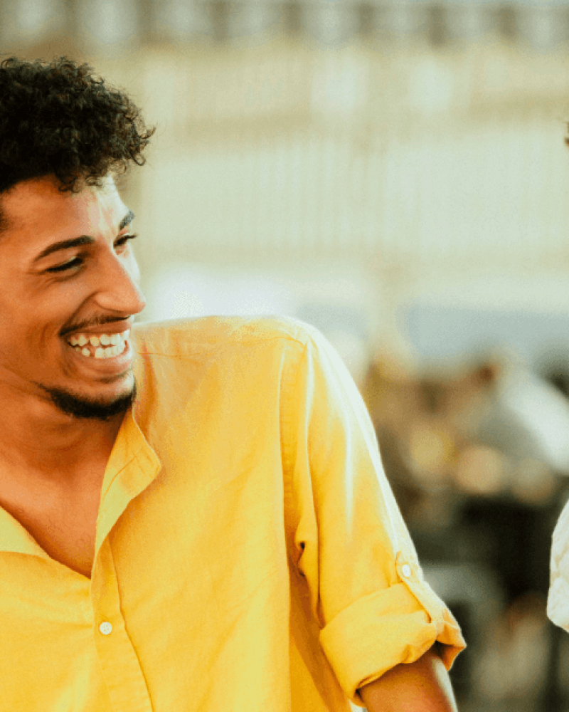 Foto de homem com camisa amarela sorrindo